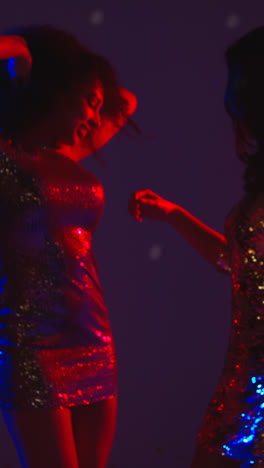 Vertical-Video-Of-Two-Women-In-Nightclub-Bar-Or-Disco-Dancing-With-Sparkling-Lights-In-Background-1